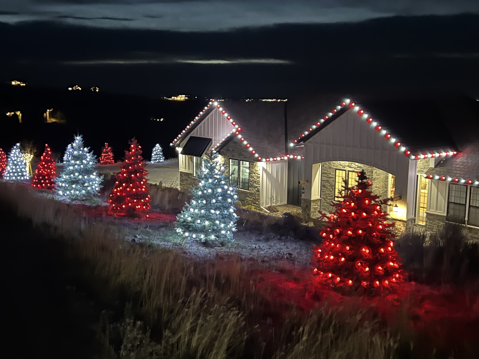 Home with red and cool white C9 lights and matching lit trees
