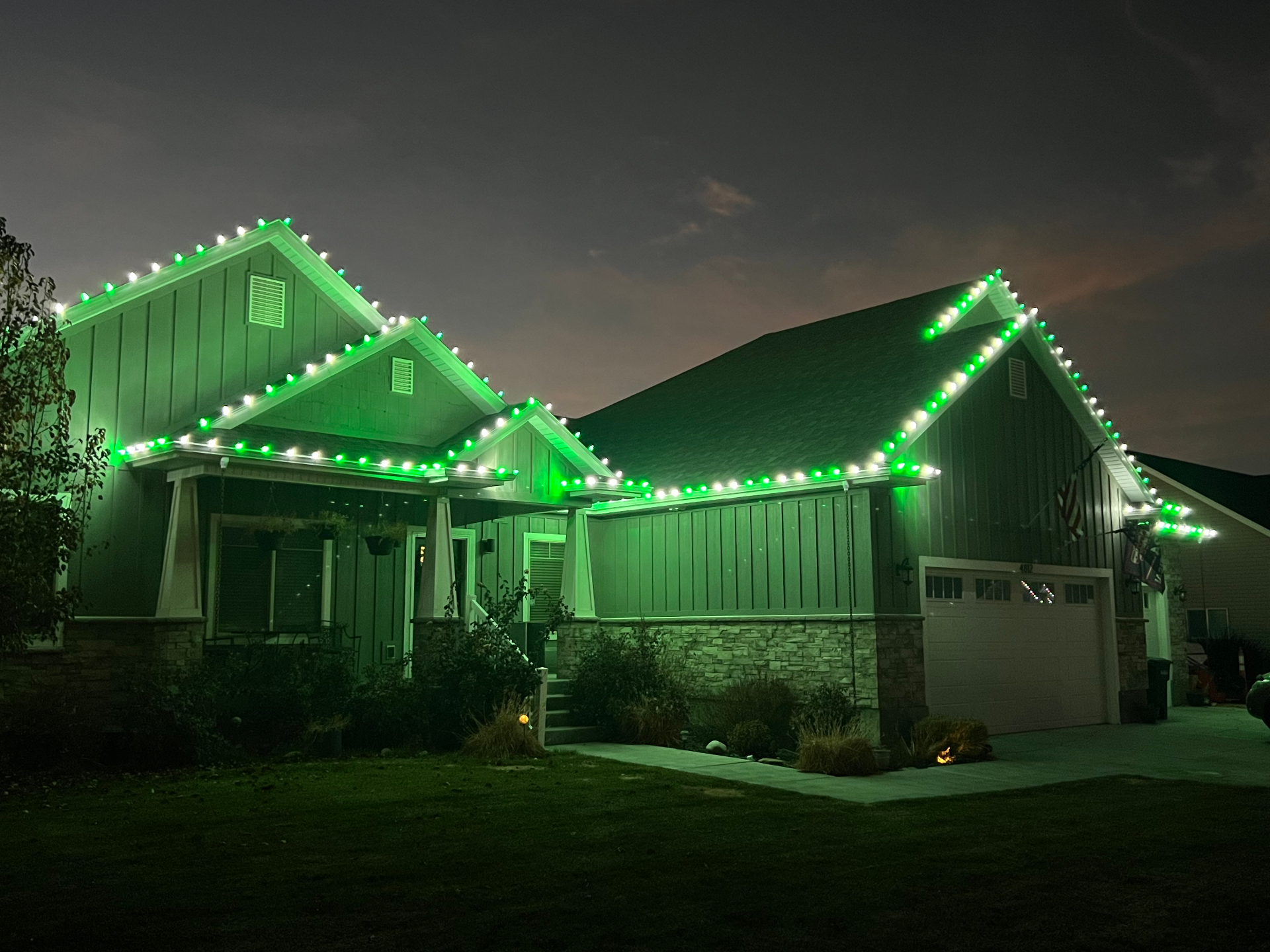 Craftsman home with green and cool white C9 Christmas lights