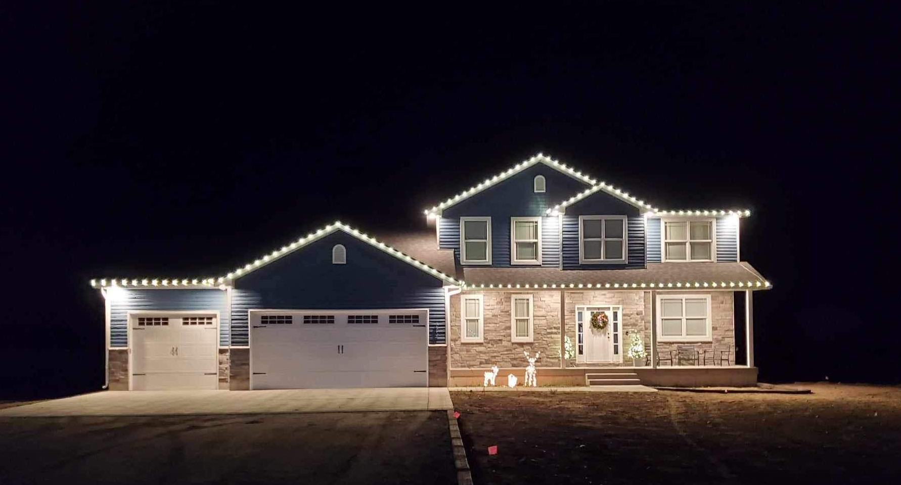 Blackfoot two-story home with warm white C9 roofline Christmas lights