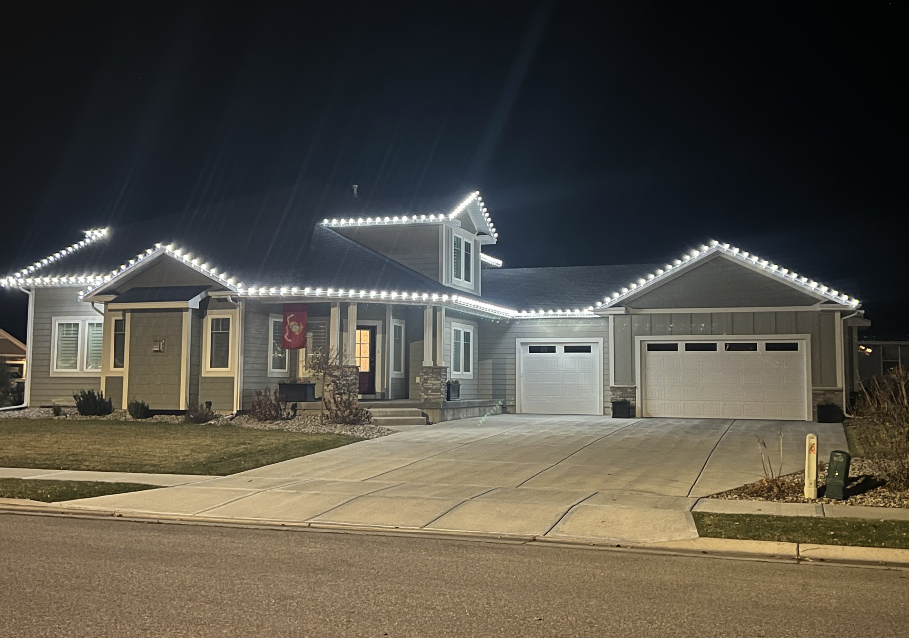 Home in Idaho Falls with cool white C9 Christmas lights along the roofline at night