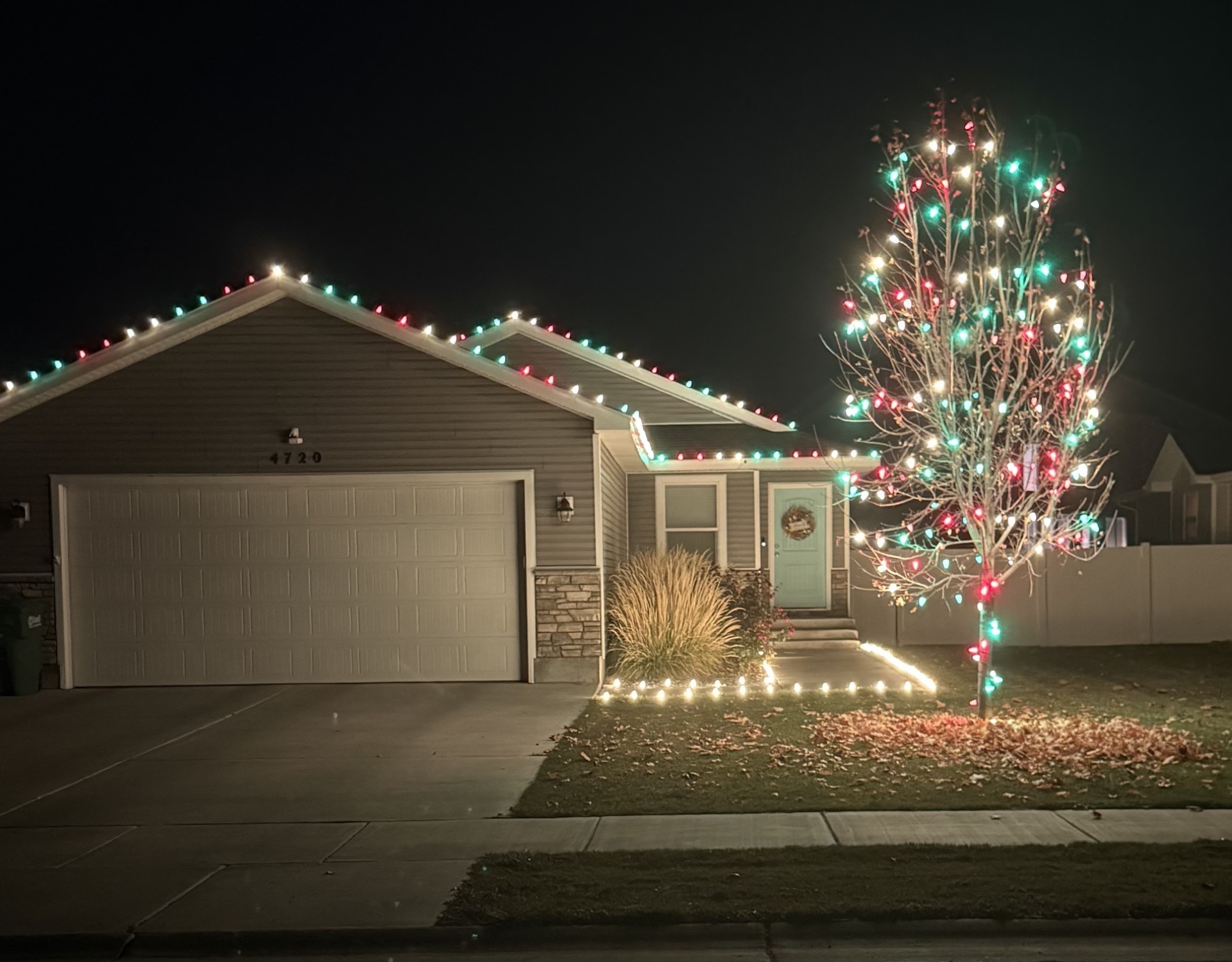 Idaho Falls home with red and green C9 roofline lights and wrapped tree